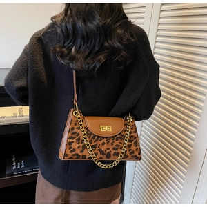 Detail of leopard print suede shoulder bag with gold chain strap and metal twist lock