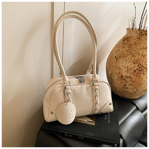 Close-up of a vintage cream-white soft leather bowling bag with side ribbon detail