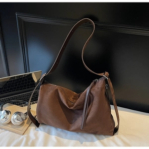 Detailed view of dark brown suede tote bag with zipper tassel and adjustable strap