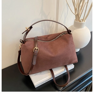 Detailed macro shot of dark brown suede Boston bag texture and smooth leather handle