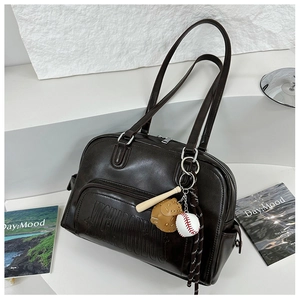 Close-up of retro dark brown leather tote bag with embossed logo and baseball charms