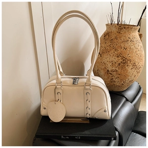 Detailed macro view of cream white patent leather bowling bag with vintage lace-up side design