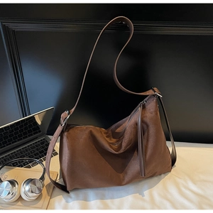 Macro detail of brown suede hobo bag with adjustable strap and silver metal buckle