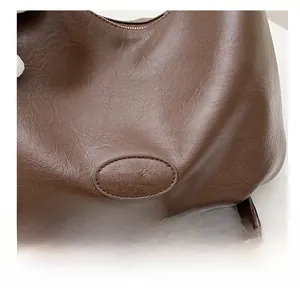 Detail of embossed FASHION & BAGS logo on retro dark brown leather backpack for women