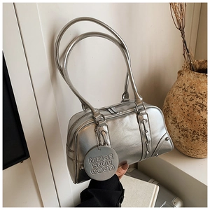 Detail of silver metallic tote bag with brand tag and textured leather finish