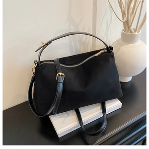 Detail of matte black commuter bag with golden zippers and synthetic leather straps