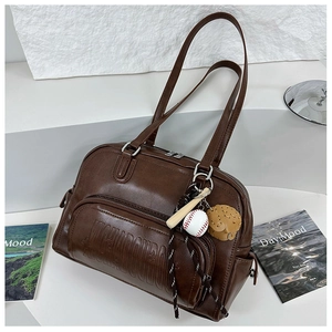 Macro view of vintage brown tote bag featuring embossed logo and detailed side zipper