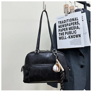 Close-up of black retro tote bag featuring a front zipper pocket and baseball keychain charm