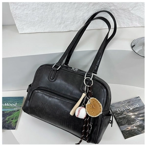 Detail of black tote bag featuring WHAT ELSE embossing and baseball themed charms