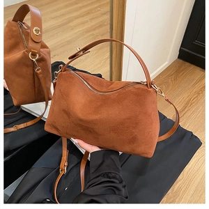 Detail of brown frosted leather tote bag with gold hardware and adjustable strap