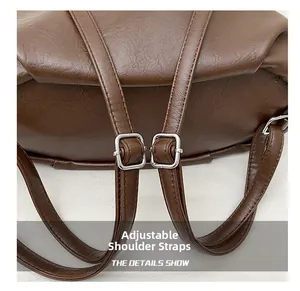 Macro shot of adjustable dark brown faux leather straps with silver metal buckles on backpack