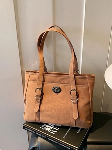 Brown faux leather tote bag with silver metal buckles and buckle strap details