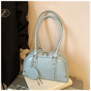 Close-up of light blue patent leather tote bag with glossy finish and metal ring detail