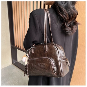 Detail of dark brown tote bag featuring Richardson embossed text and baseball charm