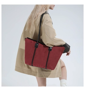 Burgundy oversized suede tote bag with black braided rope handles on model