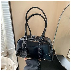 Close-up of black patent leather tote with silver rivets and quilted texture details