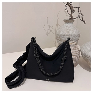 Detail of black nylon crossbody bag with dual braided and ruched shoulder straps