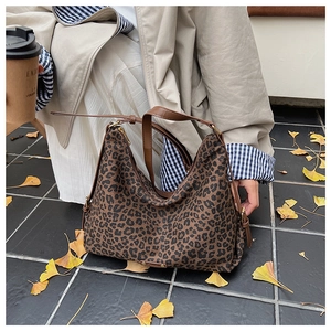 Detail der Leoparden-Stofftasche mit braunem Lederriemen auf herbstlichen Blättern