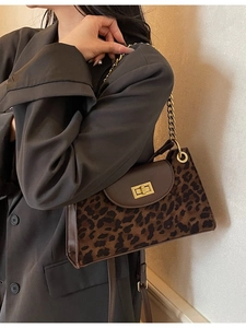 Retro leopard print shoulder bag with gold chain strap and turn-lock closure on grey blazer