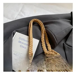 Detail der gewebten Tasche mit dicken Griffen, Perlenkette und Spitze auf grauem Anzug
