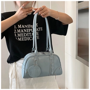 Detail of light blue PU leather handbag featuring woven ropes and a round logo pendant