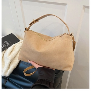 Detail of camel suede hobo bag with gold zipper and adjustable leather shoulder strap