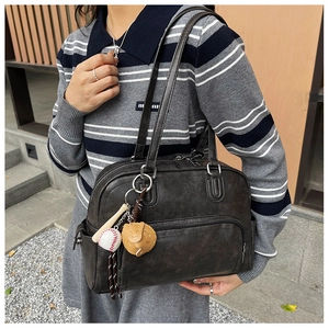 Detailed shoulder view of a vintage charcoal tote bag with baseball themed keychains