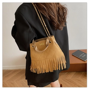 Détail d'un sac seau vintage marron à franges avec matelassage en losanges et chaîne dorée