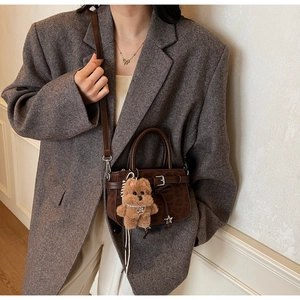 Detail of leopard print suede mini crossbody bag with cute plush puppy charm
