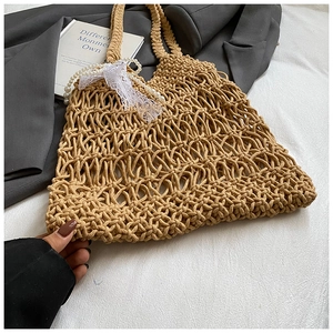 Detailansicht der handgewebten Netztasche mit Perlenanhängern und Schleife aus Spitze