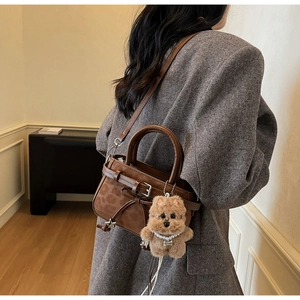 Detail view of vintage leopard brown handbag with cute plush dog pendant and star charm