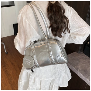 Close-up of metallic silver tote bag with lace-up detail and round brand tag