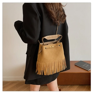 Détail du sac seau kaki avec des franges et un motif matelassé en losanges chic