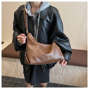 Detailaufnahme der braunen Vintage-PU-Leder-Einkaufstasche mit Fashion-Metallemblem