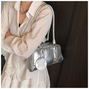 Silver metallic tote bag shown as a shoulder bag on a white dress with double zippers