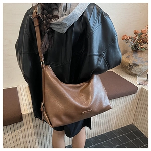 Detail der braunen Hobo-Tasche mit verstellbarem Riemen und Metallteilen im Streetstyle