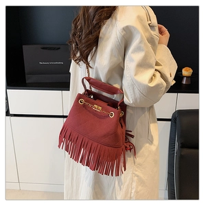 Détail du sac seau bordeaux à franges avec texture daim matelassée et chaîne dorée