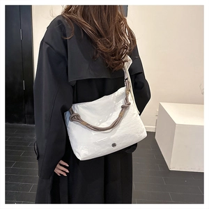 Minimalist white textured crossbody bag with grey rope handle shown on person