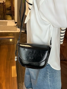 Minimalist black crescent saddle bag with glossy oil wax finish and silver ball pendants