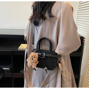 Detail of leopard print mini handbag with plush puppy charm and metallic star detail