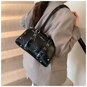 Detail of black glossy leather tote bag with silver studs and metal ring accents
