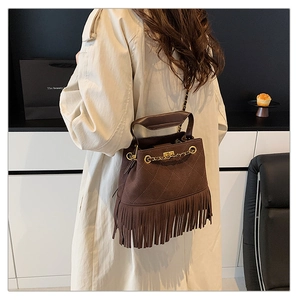 Détail du sac à franges matelassé marron foncé avec chaîne dorée et fermoir pivotant