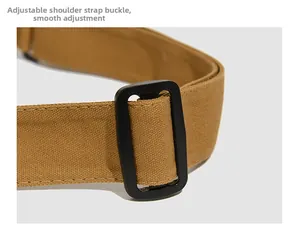 Gros plan sur la bandoulière réglable en toile kaki avec boucle noire lisse