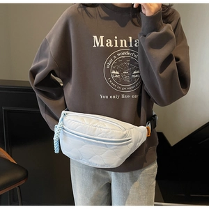 Détail du sac bandoulière matelassé bleu clair avec motifs à vagues et tirette tissée