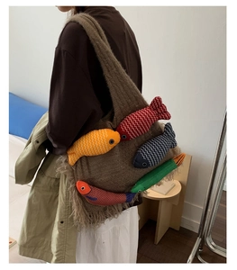 Close-up of brown knit tote bag with colorful 3D fish dolls and tassel fringe details