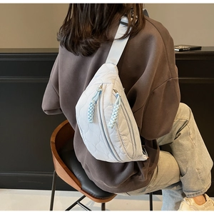 Détail du sac de poitrine en toile matelassée avec doubles fermetures éclair et cordons