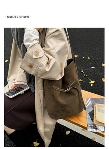 Vue détaillée d'un sac seau en daim marron avec cordon en cuir sur un banc en bois