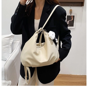 Detail of off-white large tote bag with textured PU leather and plush cloud charm accessory