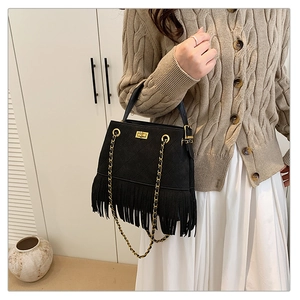 Détail du sac seau noir à franges en daim avec surpiqûres losanges et chaîne dorée