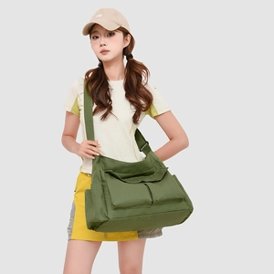 Détail du grand sac bandoulière vert en tissu Oxford avec deux poches frontales